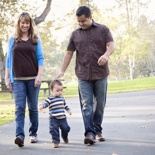 Happy Young Mixed Race Ethnic Family Walking In The Park.